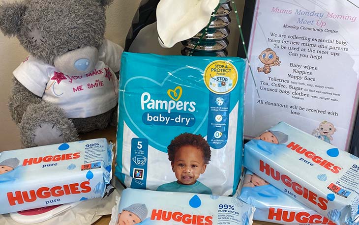 Baby nappies and wipes set next to a teddy bear.